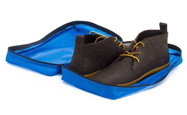 A pair of shoes in an open Island (blue) Aether End Pocket Packing Cube for the Aeronaut 45.